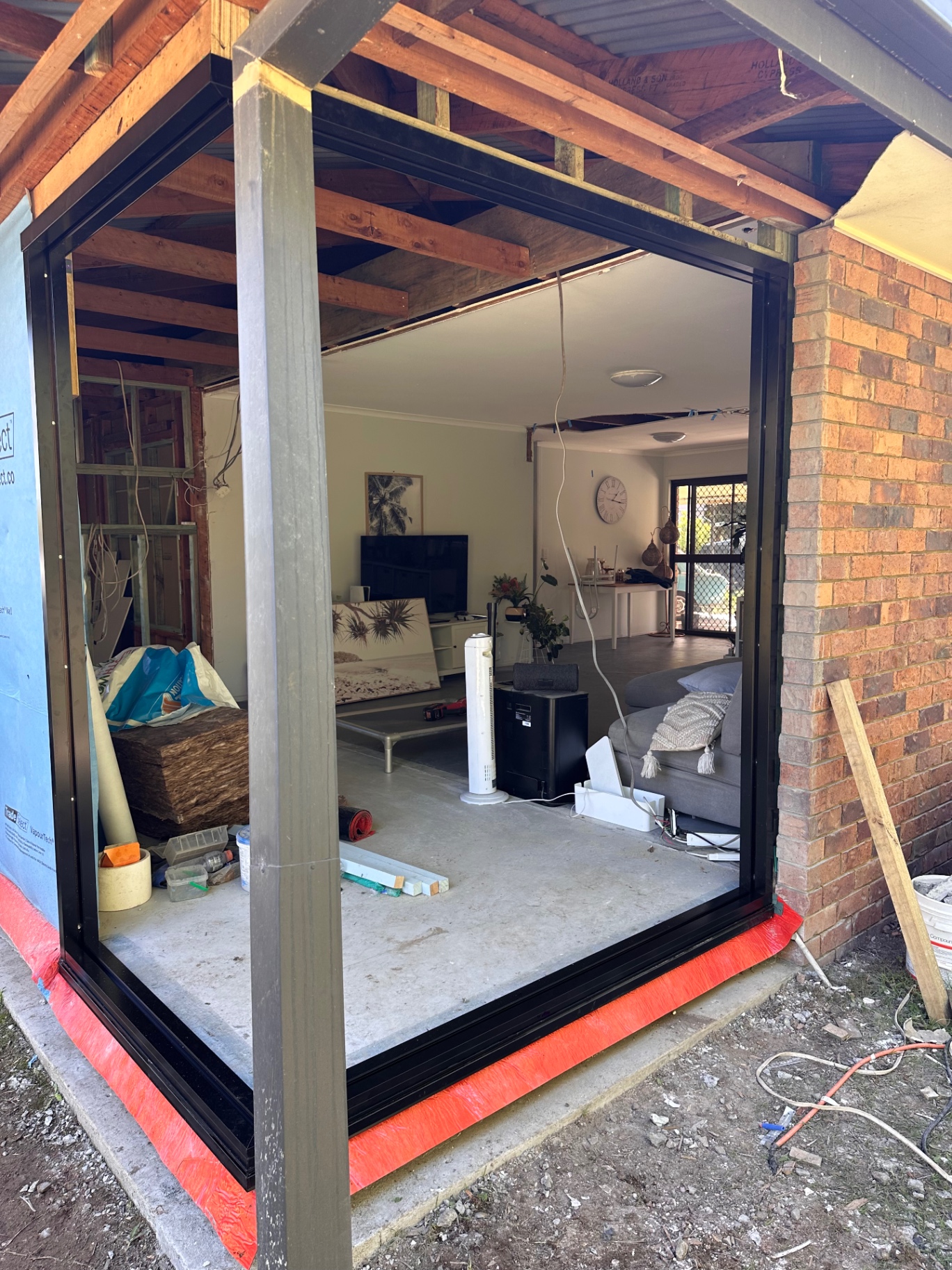 New black-framed doorway fitted into a brick exterior wall