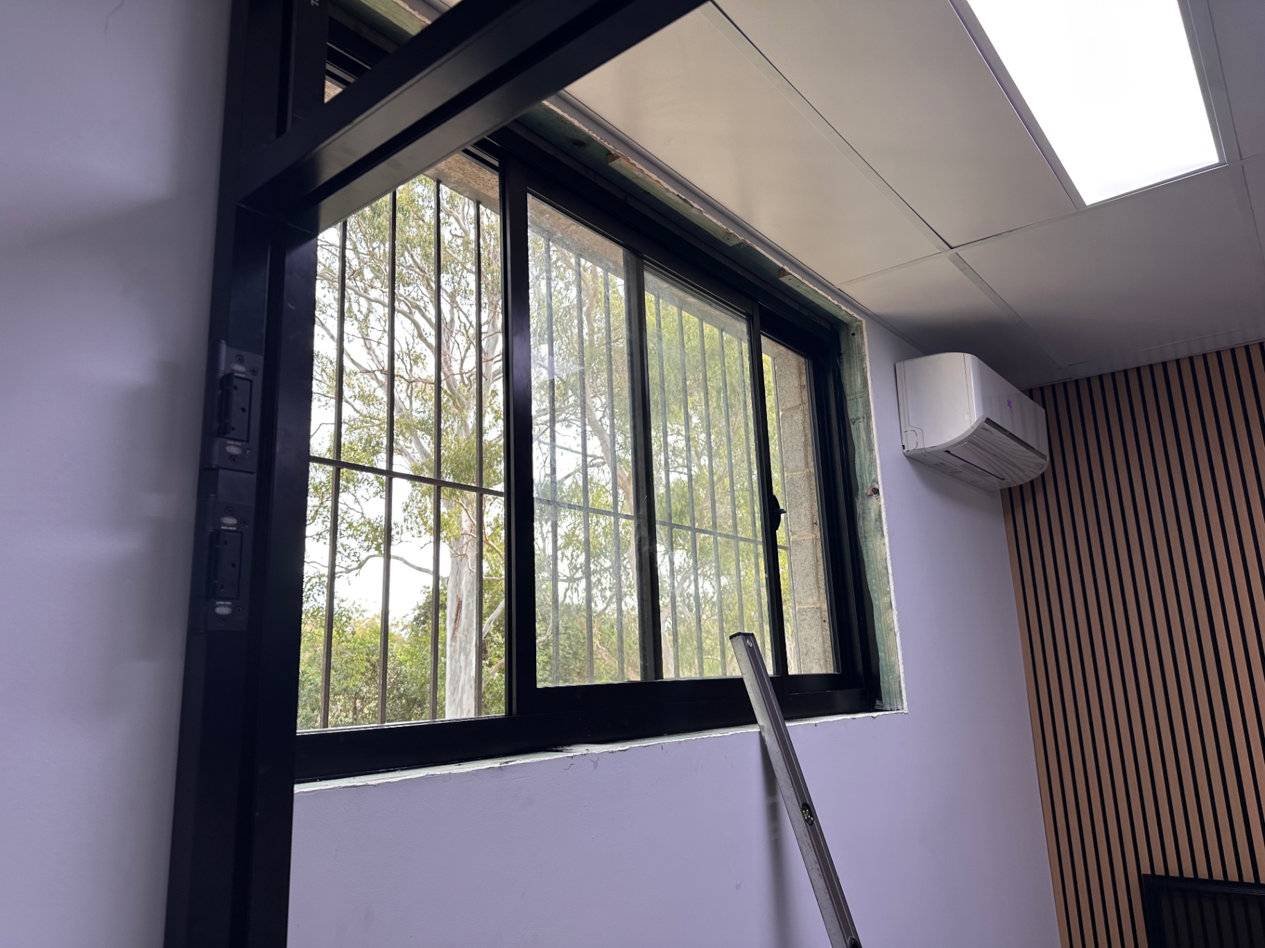 Finished black-framed window installed in a bright interior wall